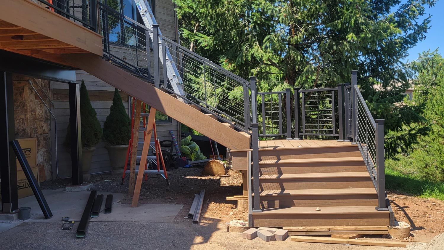 Composite deck stairs with black metal balusters and a wood top rail