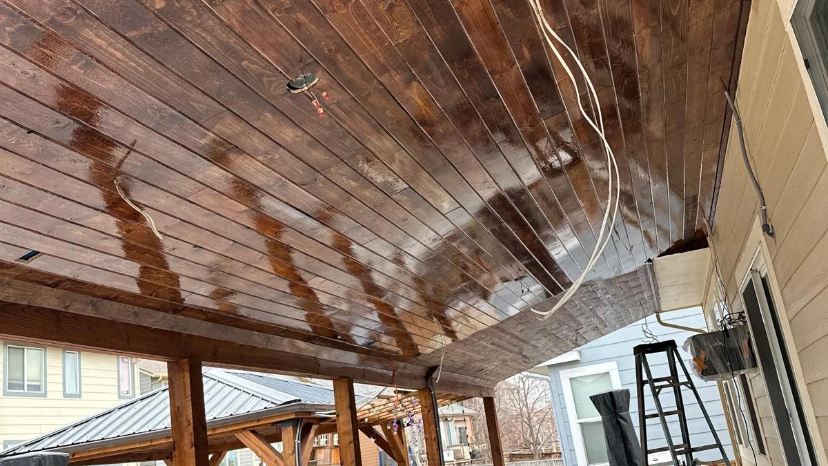 Covered patio with a stained tongue-and-groove wood plank ceiling and recessed lighting