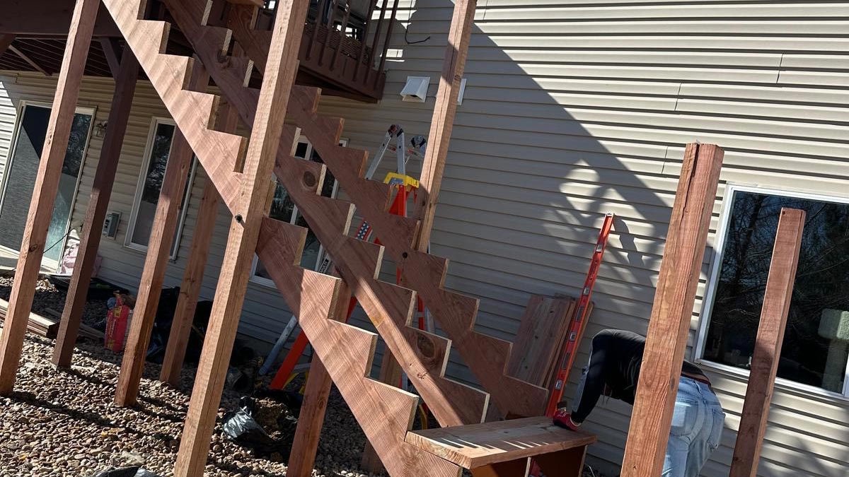 Finished wooden deck staircase descending from an elevated deck at a Denver-area home