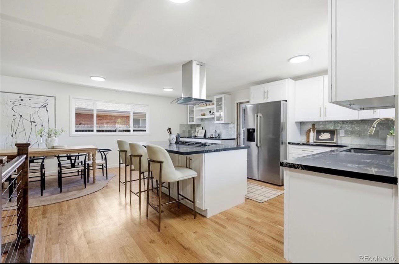 Open white kitchen with peninsula, compact island and range hood arranged for an efficient established-home floor plan