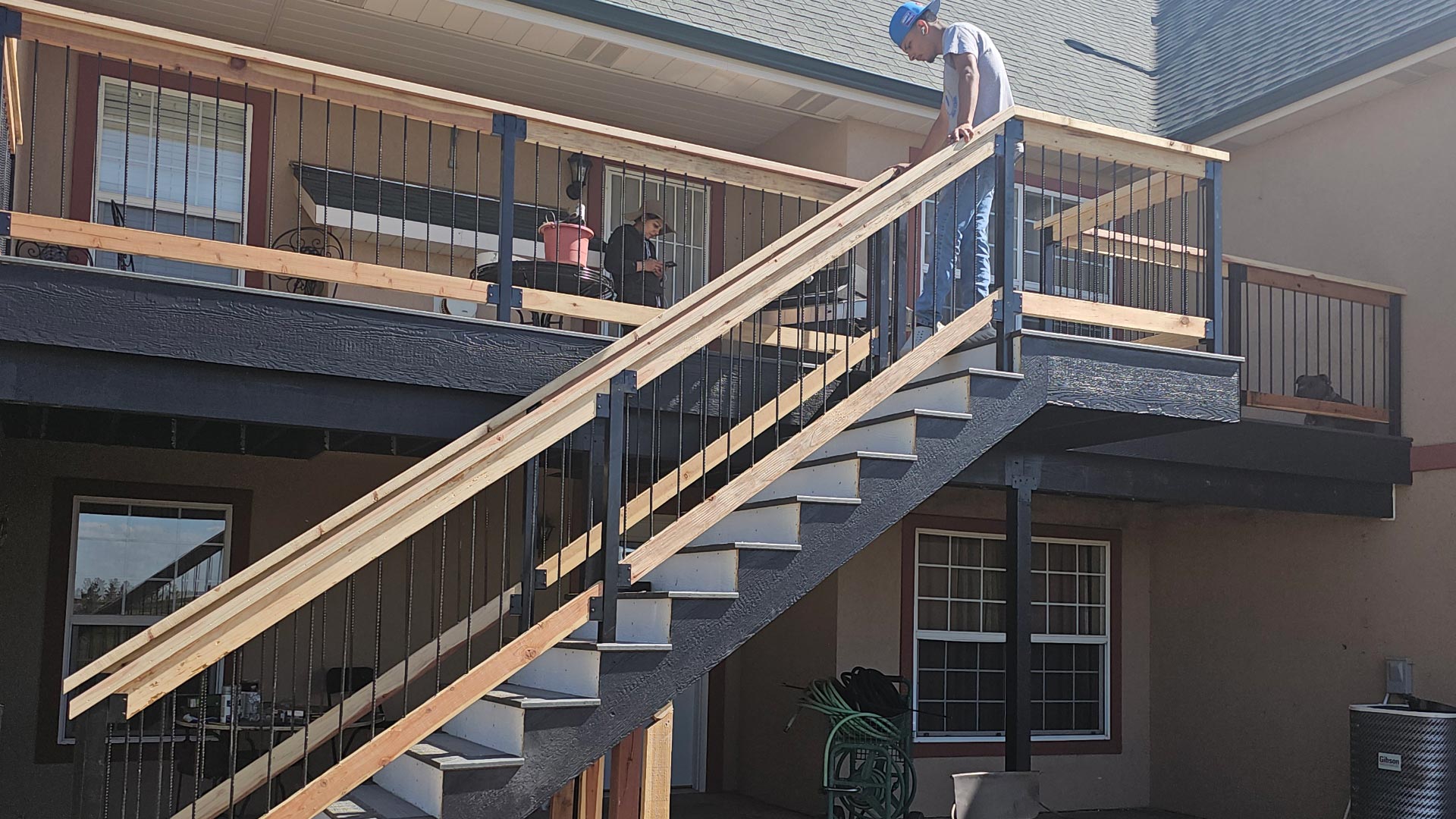 Second-story deck and exterior staircase under construction with framing exposed