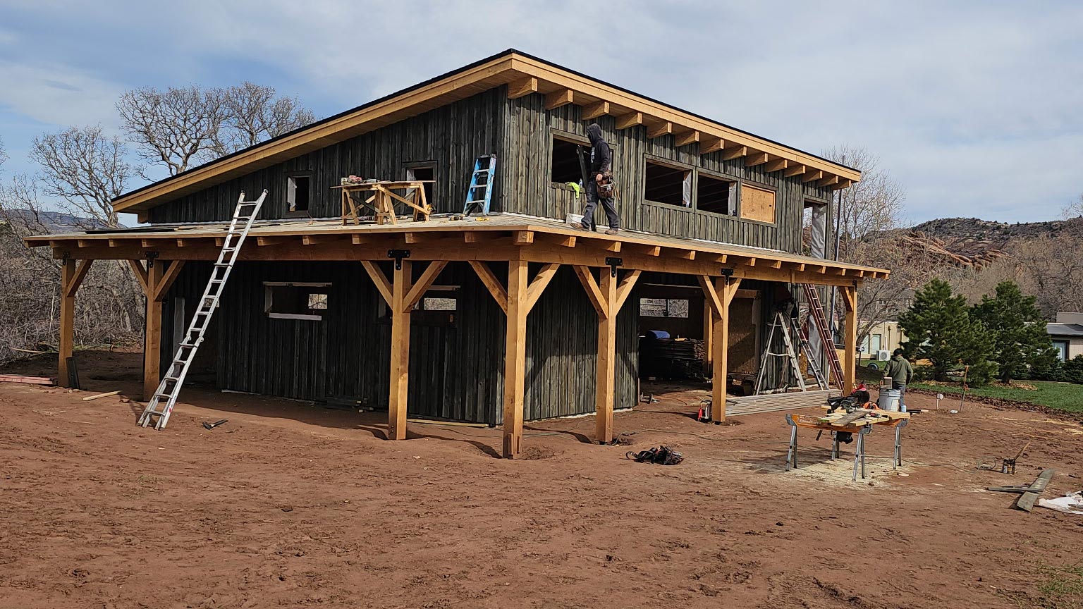 Building exterior with weathered gray vertical wood siding and heavy timber posts