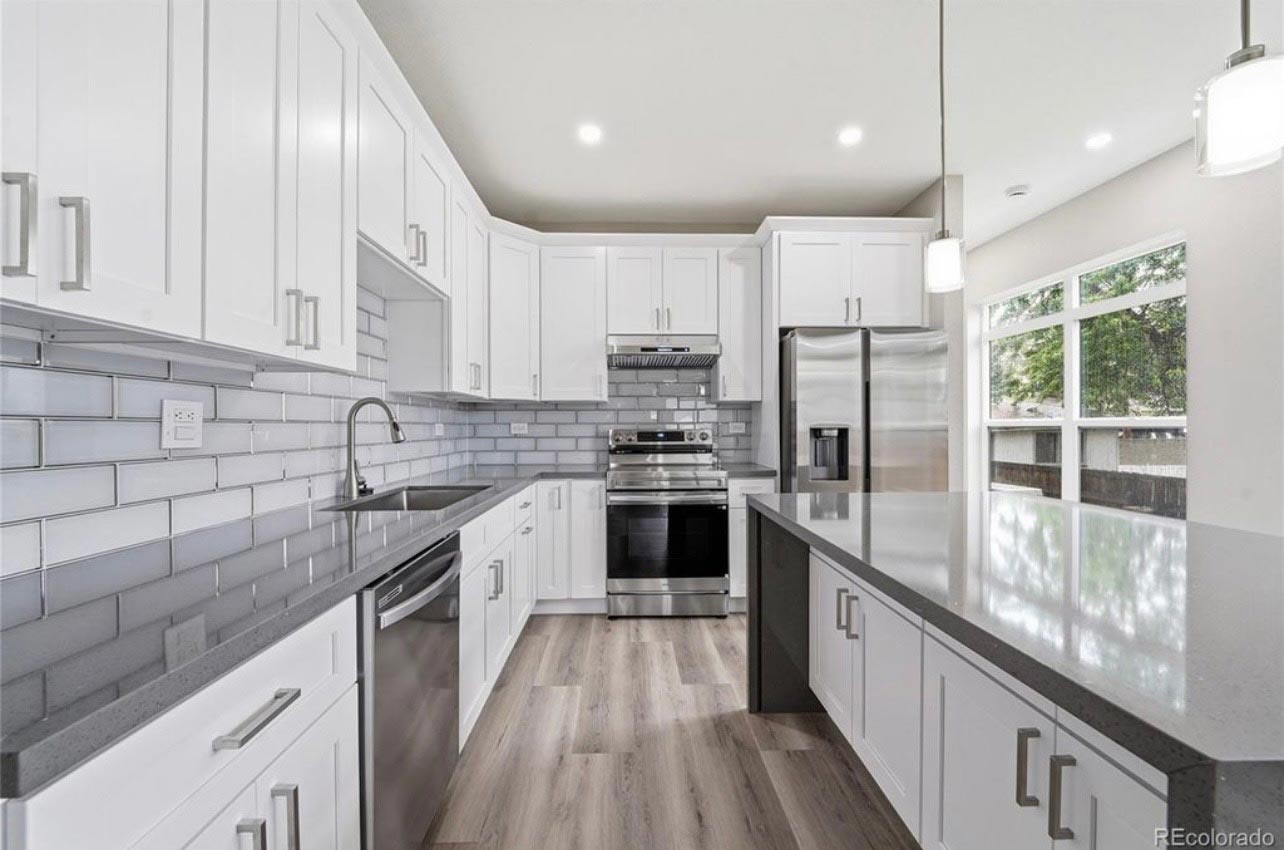 White shaker kitchen with gray subway tile backsplash and quartz countertops