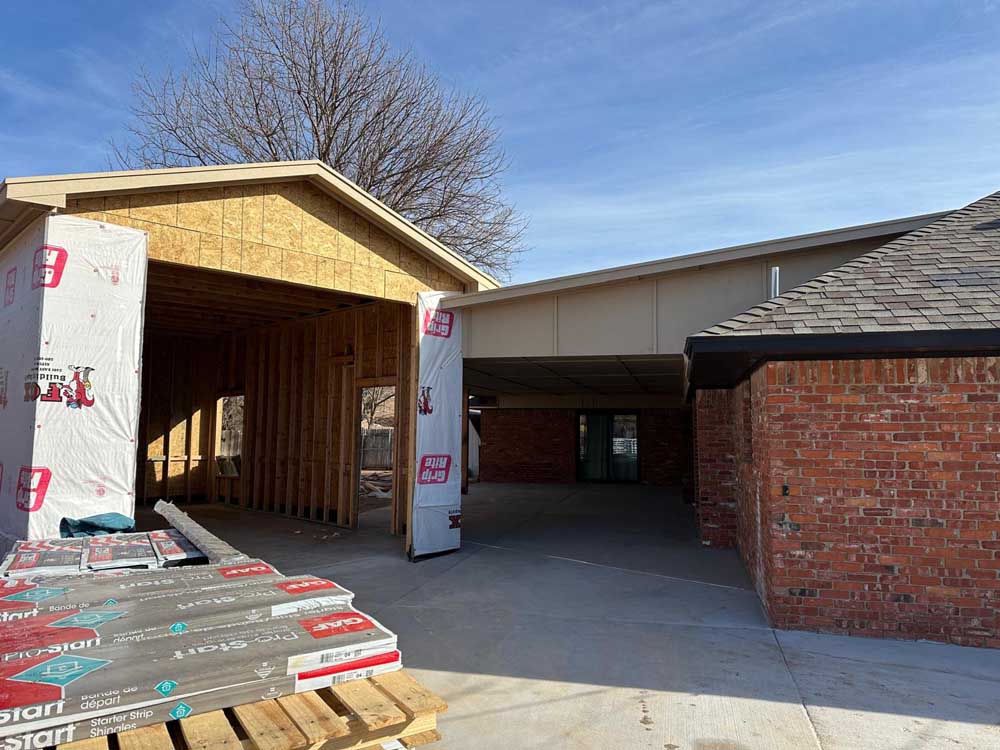 New garage addition framing tied into an existing brick house