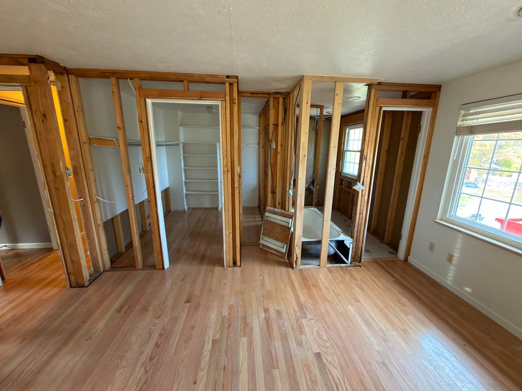 Denver Master Bedroom Remodel: First Framing Update Exposed wall framing and closet openings beside the bathroom area during a Denver master bedroom remodel.