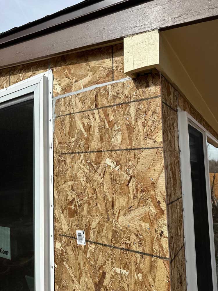 Exterior Repair at the Roof Edge Exterior corner with exposed OSB sheathing at the roof edge and gutter during a Denver-metro repair