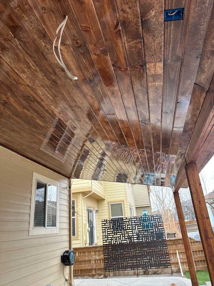 Covered patio wood ceiling metal privacy screen — exterior remodel by BH Builders, Denver metro