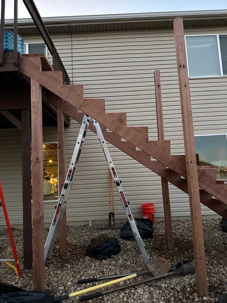 Deck stair stringers framing tan siding — exterior remodel by BH Builders, Denver metro