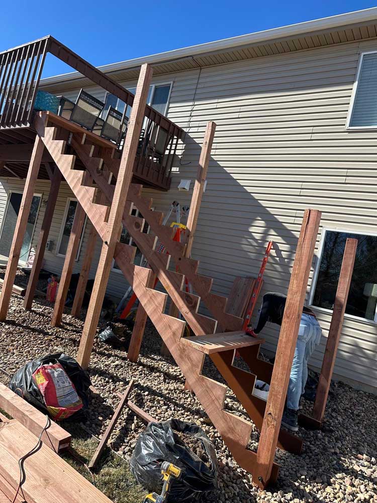 Deck staircase construction sunny tan siding — exterior remodel by BH Builders, Denver metro