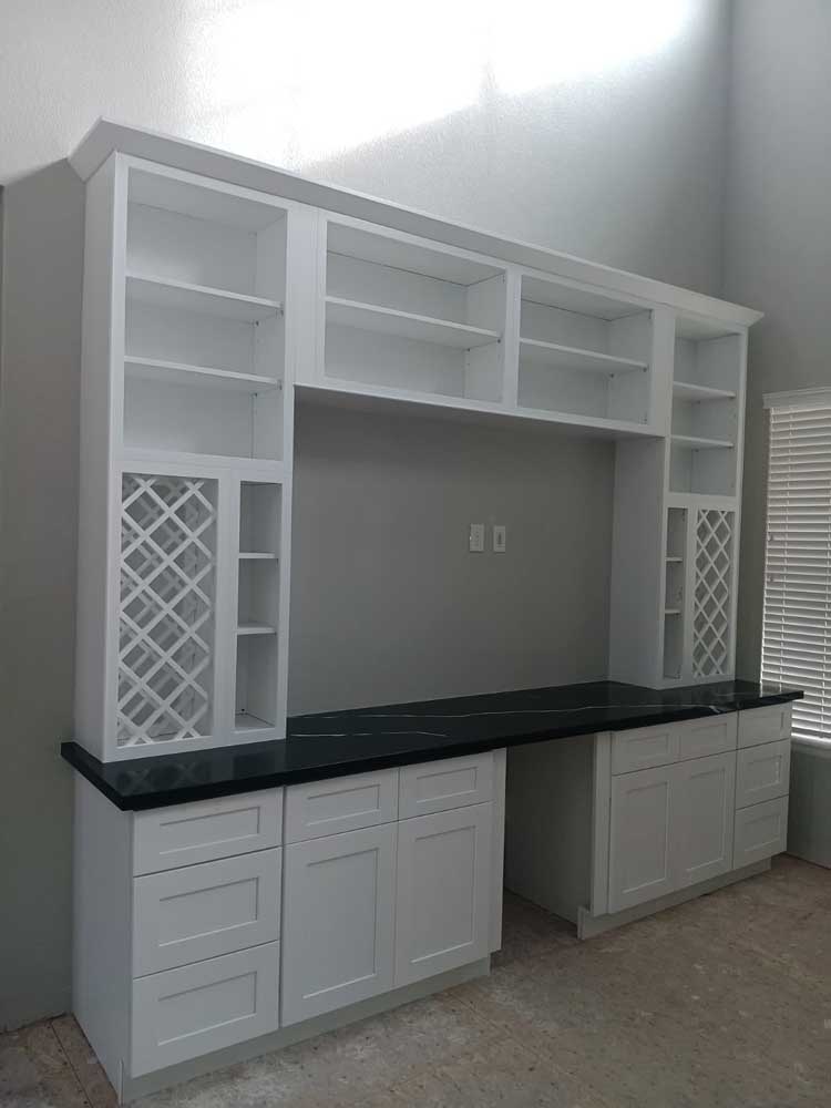 White kitchen cabinets with a built-in hutch and wine rack, semi-custom cabinetry by BH Builders