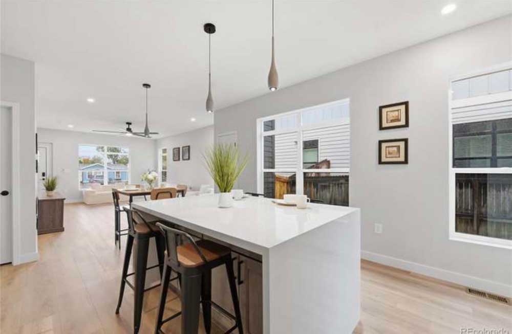 Open concept kitchen white waterfall island bar stools — kitchen remodel by BH Builders, Denver metro
