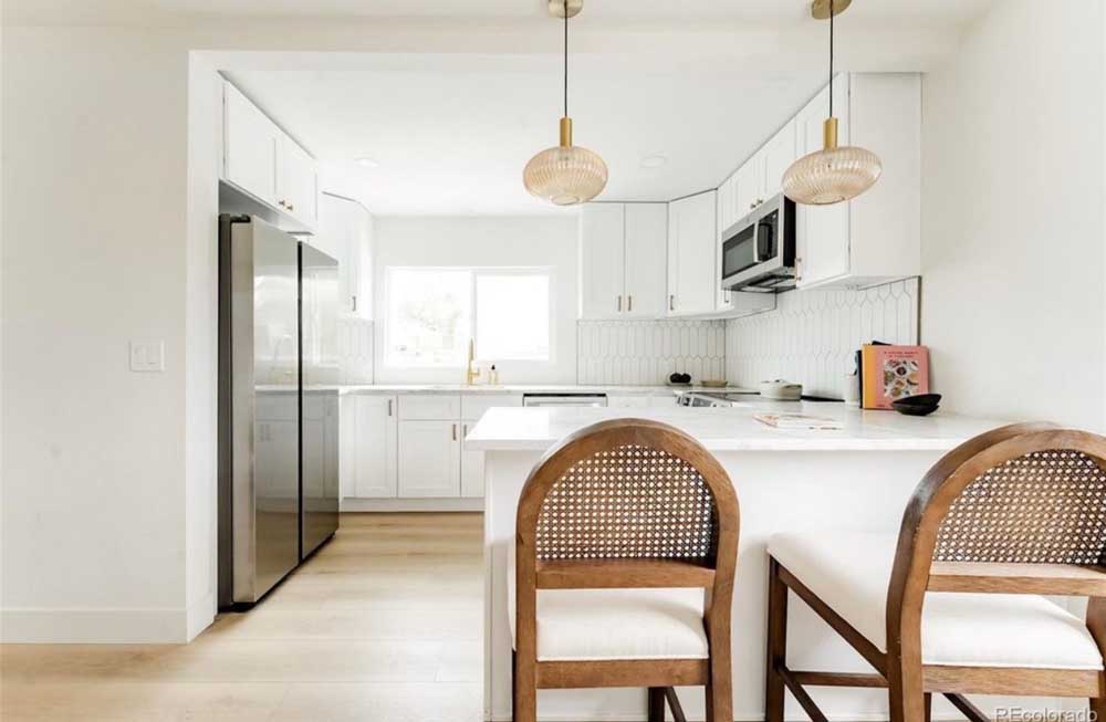 White kitchen peninsula picket backsplash cane chairs — kitchen remodel by BH Builders, Denver metro