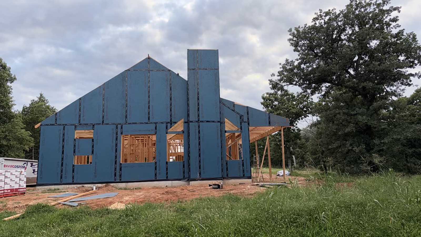 Custom home under construction with exterior sheathing complete and the chimney chase framed