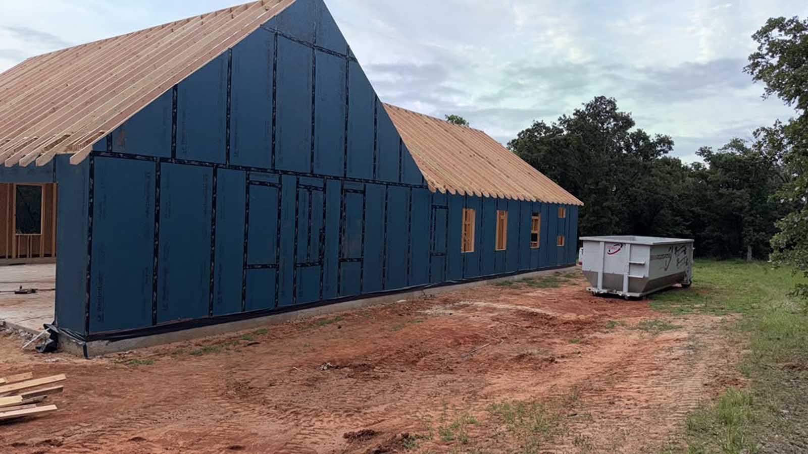 Custom home under construction showing sheathing, headers, rough openings and roof framing