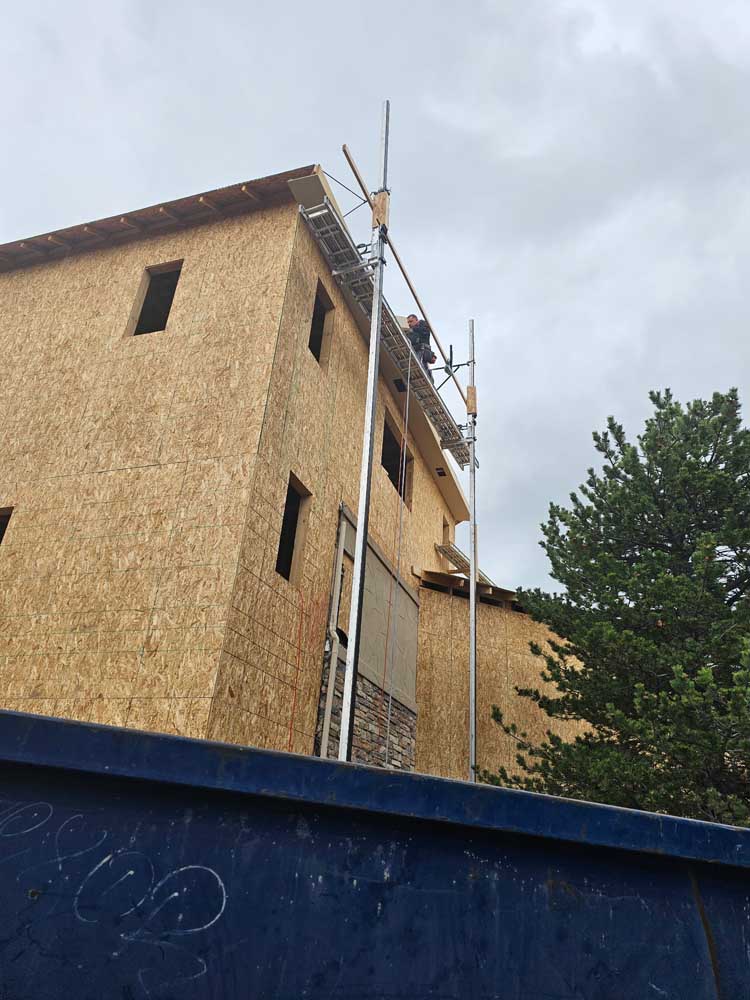 Exterior sheathing being installed on a three-story home under construction